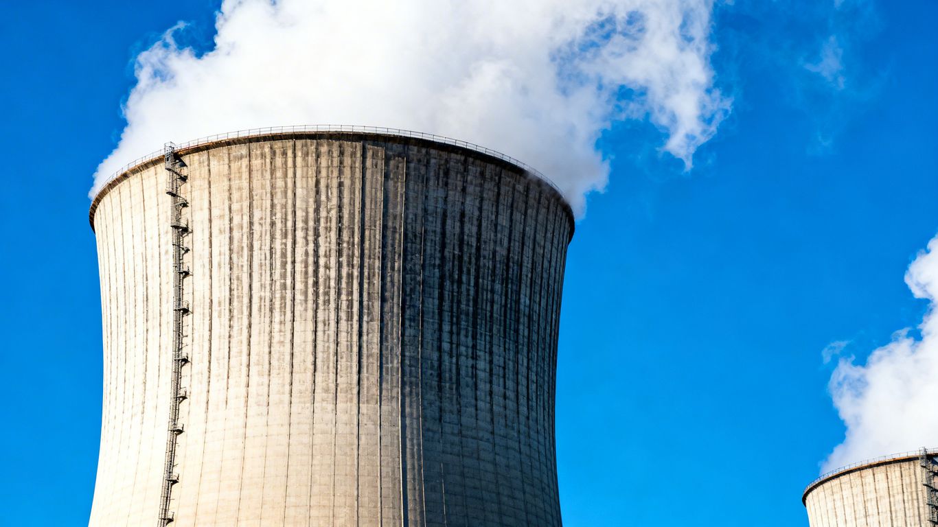 Tours de refroidissement d'une centrale nucléaire sous un ciel bleu.